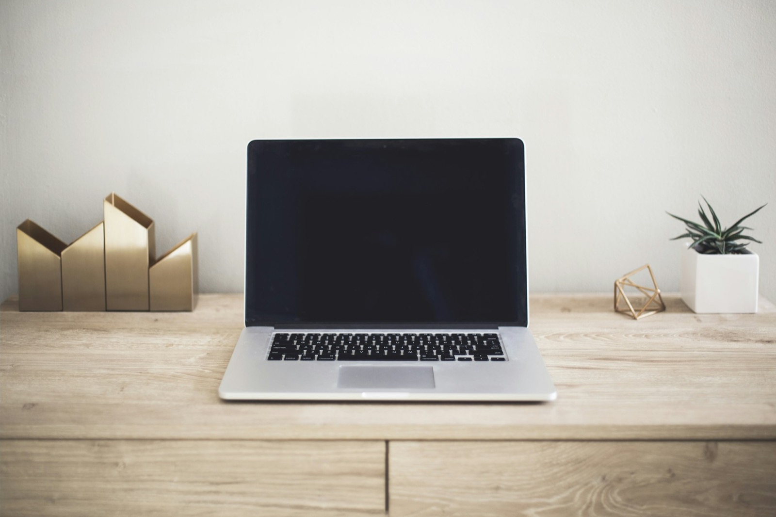 A tidy desk with a laptop showing a website being worked on